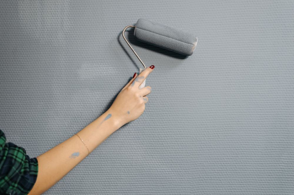 Rouleau de peinture posé sur un escabeau